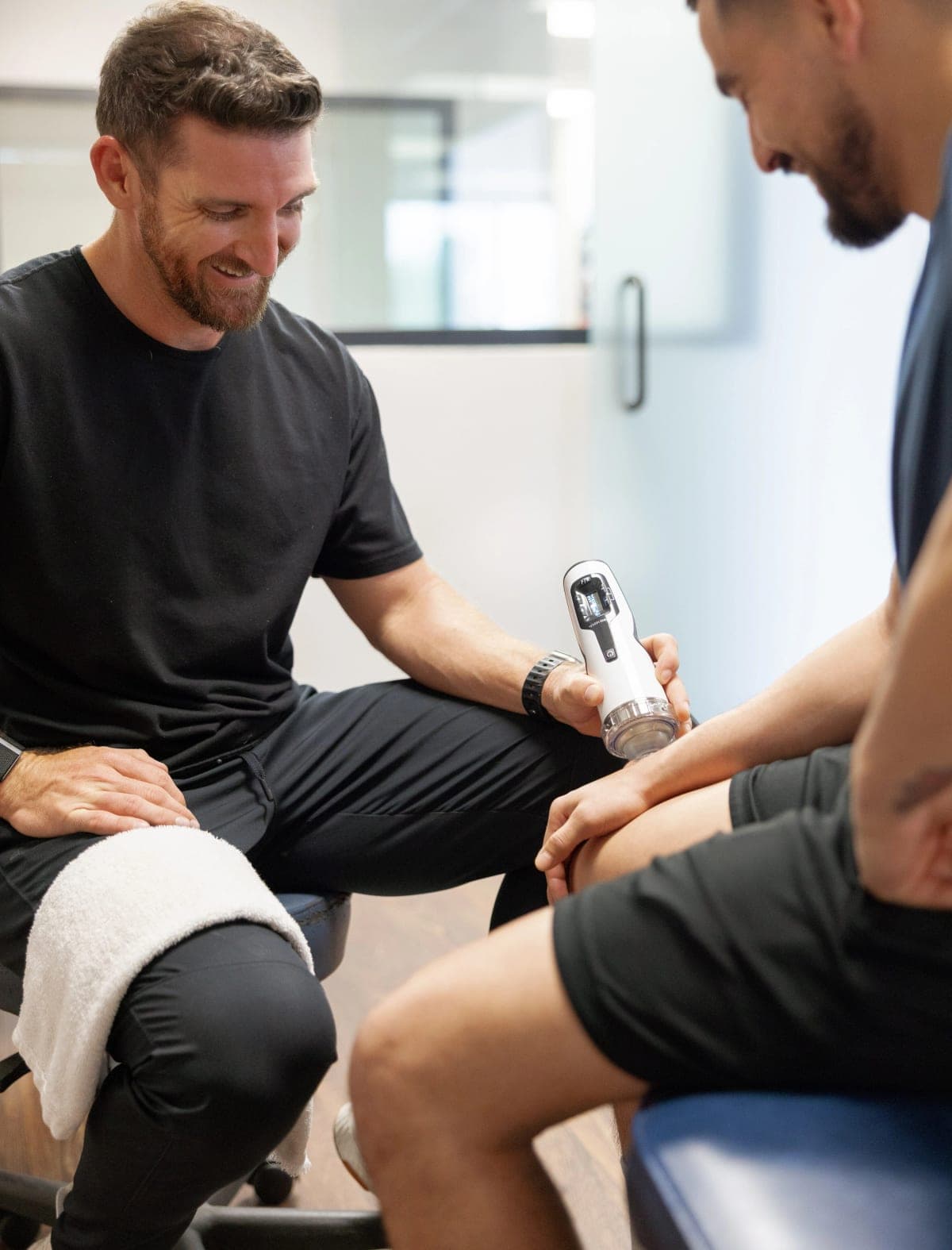 Dr. Brennan applying focused shockwave to a patient's knee while talking them through it